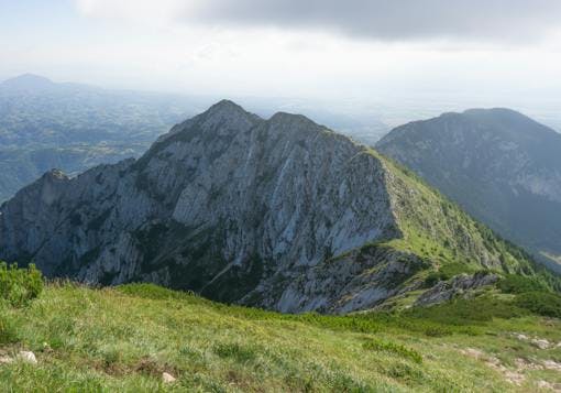 Romania's Carpathian Mountains are shown, with a prominent boulder emerging from the hill side and forming small peaks. 