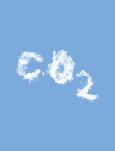 White puffy clouds form a C, an O, and a subscript 2 to represent carbon dioxide; they're set against a blue sky. The text is centered in the frame.