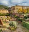 The Generalife Gardens of the Alhambra Palace, a UNESCO World Heritage Site, are shown with their intricate designs and the palace in the background. It appears to be gold hour during autumn, with soft, warm yellows and greens on the trees and plants.
